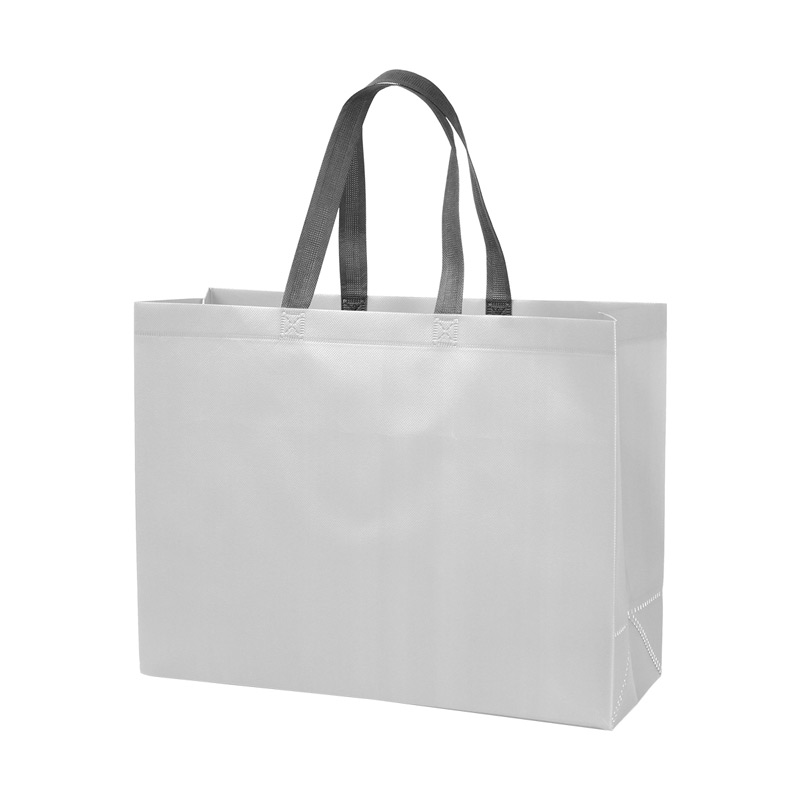 TX-222, Bolsa fabricada en tela non-woven laminado con asas superiores en color gris. El non-woven es un material duradero y de alta calidad que proporciona una barrera efectiva contra la humedad y otros elementos externos. 