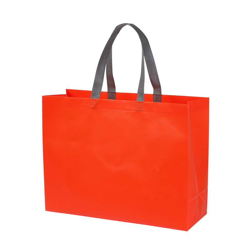 TX-222, Bolsa fabricada en tela non-woven laminado con asas superiores en color gris. El non-woven es un material duradero y de alta calidad que proporciona una barrera efectiva contra la humedad y otros elementos externos. 